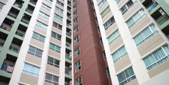Low-angle view of a modern apartment complex in Bangkok with diverse facade colors.